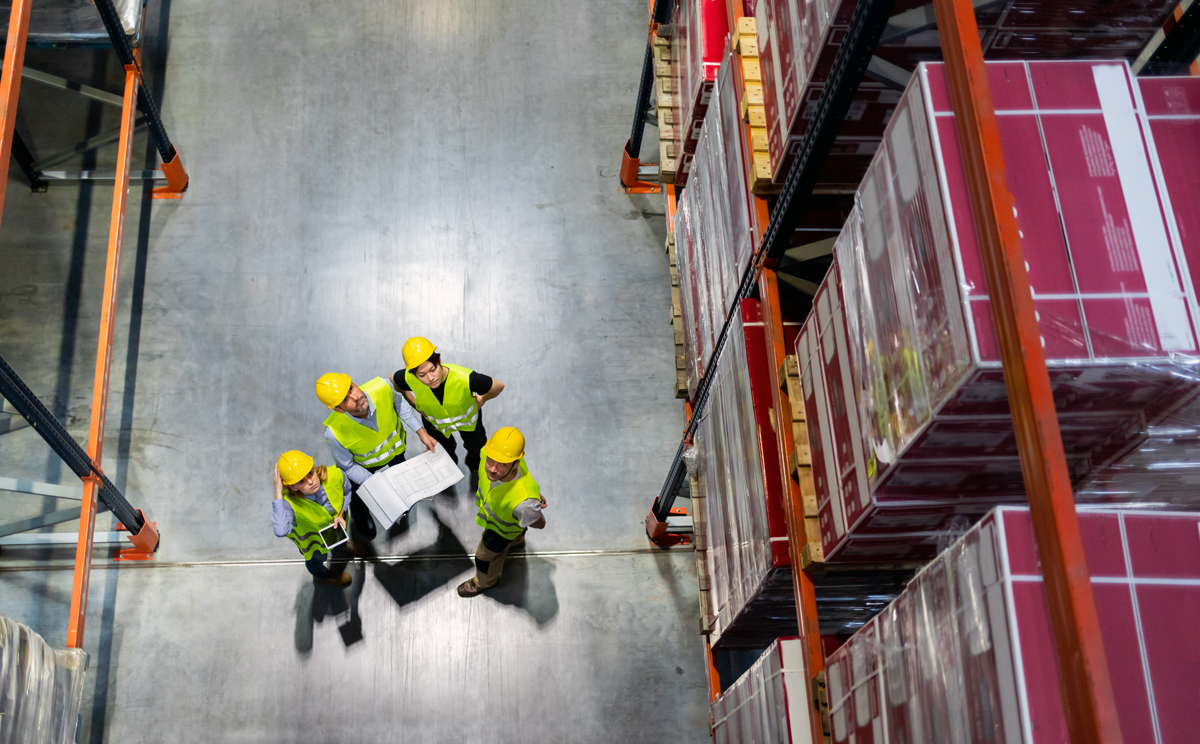 warehouse-manager-and-workers-consult-plans-betwee-2026-01-05-23-12-58-utc